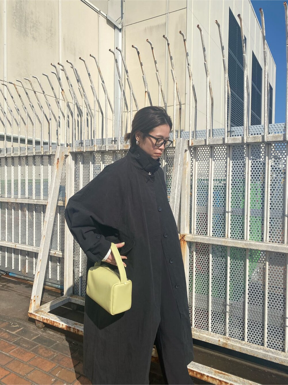 ブラック系のパンプス、ブラック系のステンカラーコート、ブラック系のスラックスを着用したレディースの冬コーディネートの3枚目の写真