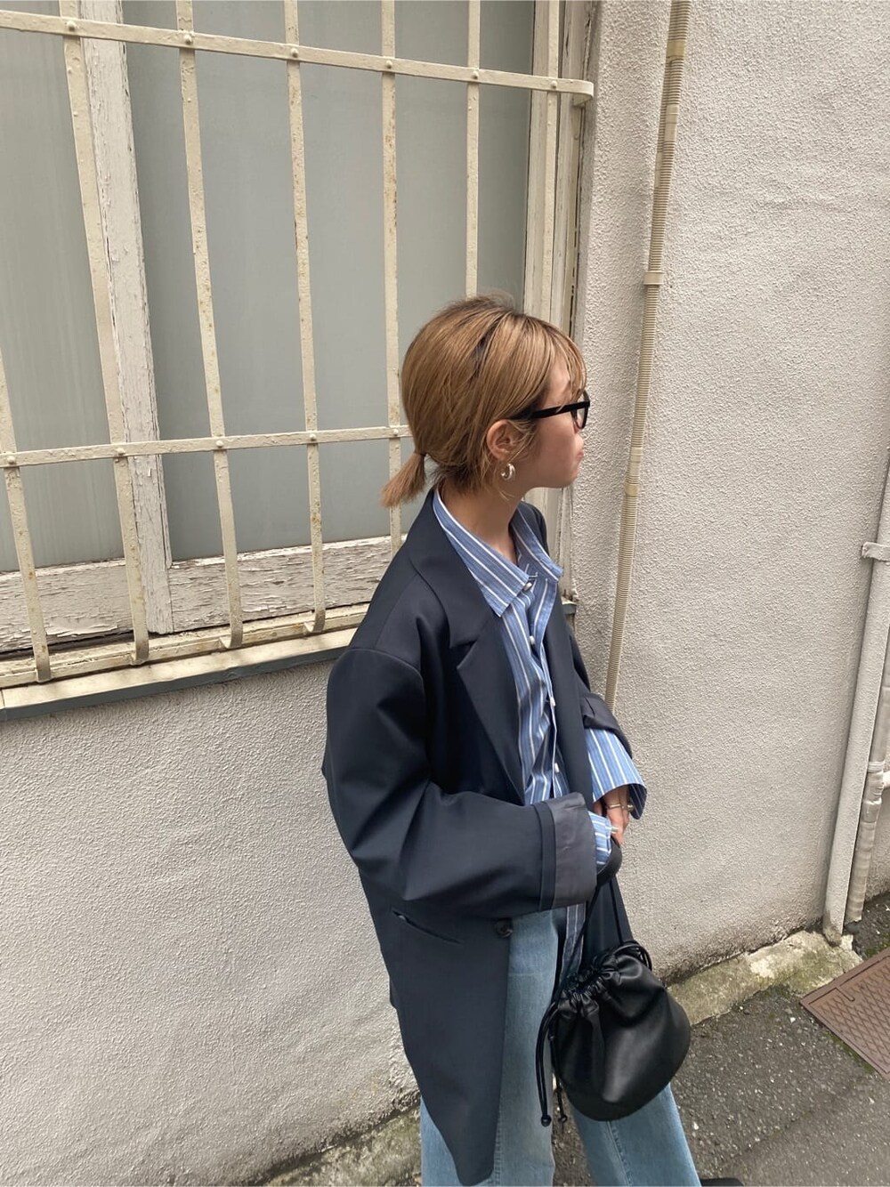 ブルー系のシャツ/ブラウス、ブラック系のパンプス、ブルー系のデニムパンツを着用したレディースの春コーディネートの5枚目の写真