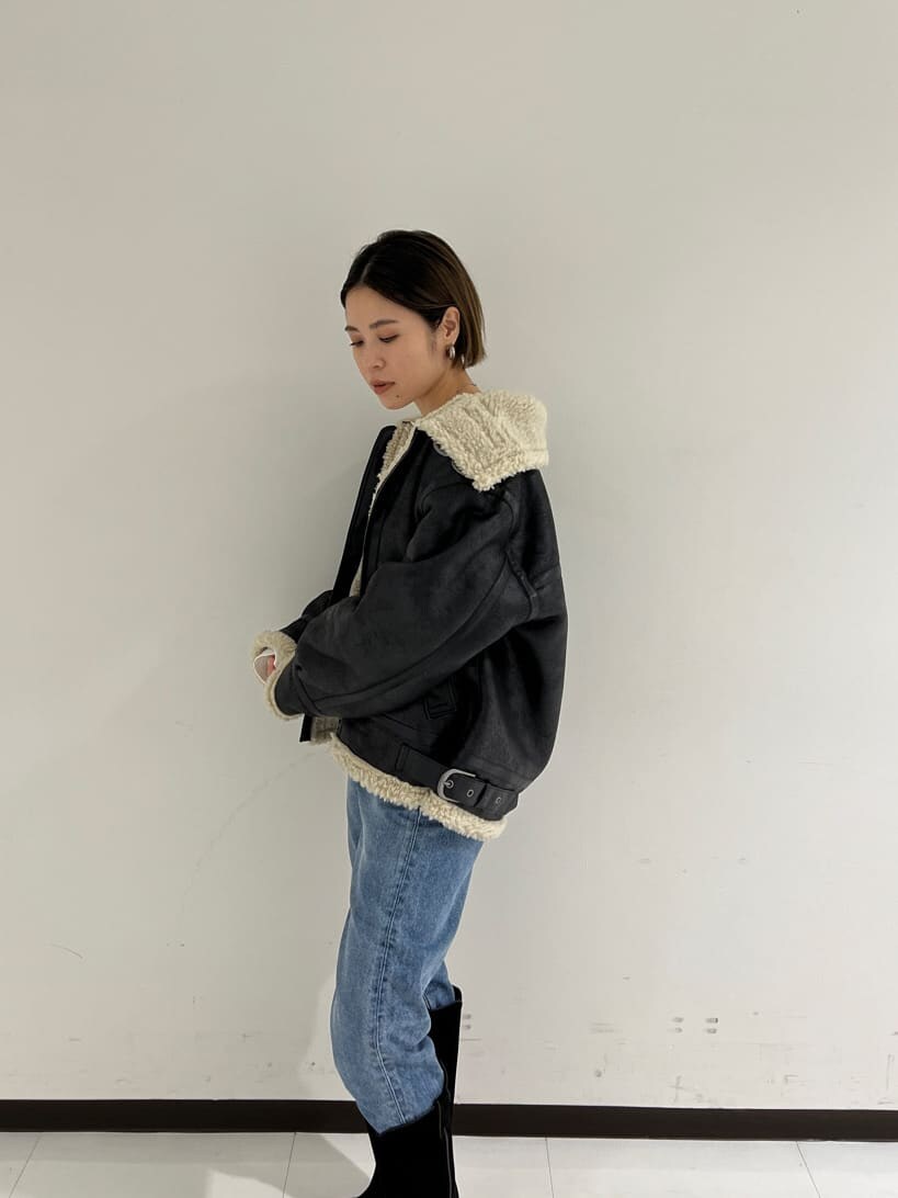 ブラック系のブルゾン、ブラック系のブーツ、ブルー系のデニムパンツを着用したレディースの秋コーディネートの3枚目の写真