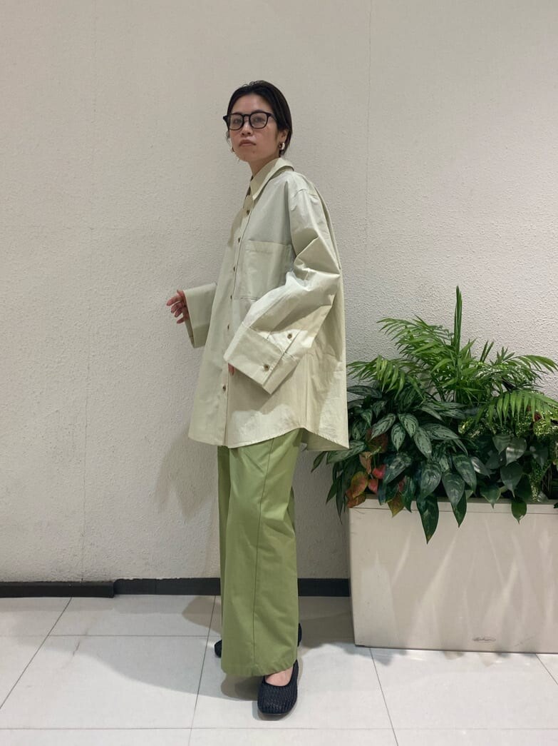 グリーン系のシャツ/ブラウス、ブラック系のパンプス、グリーン系のスラックスを着用したレディースの冬コーディネートの2枚目の写真