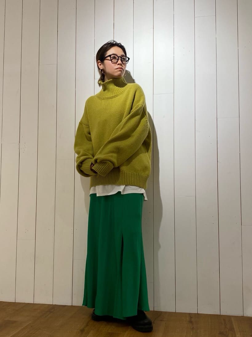グリーン系のスカート、グリーン系のニット/セーターを着用したレディースの秋コーディネートの2枚目の写真