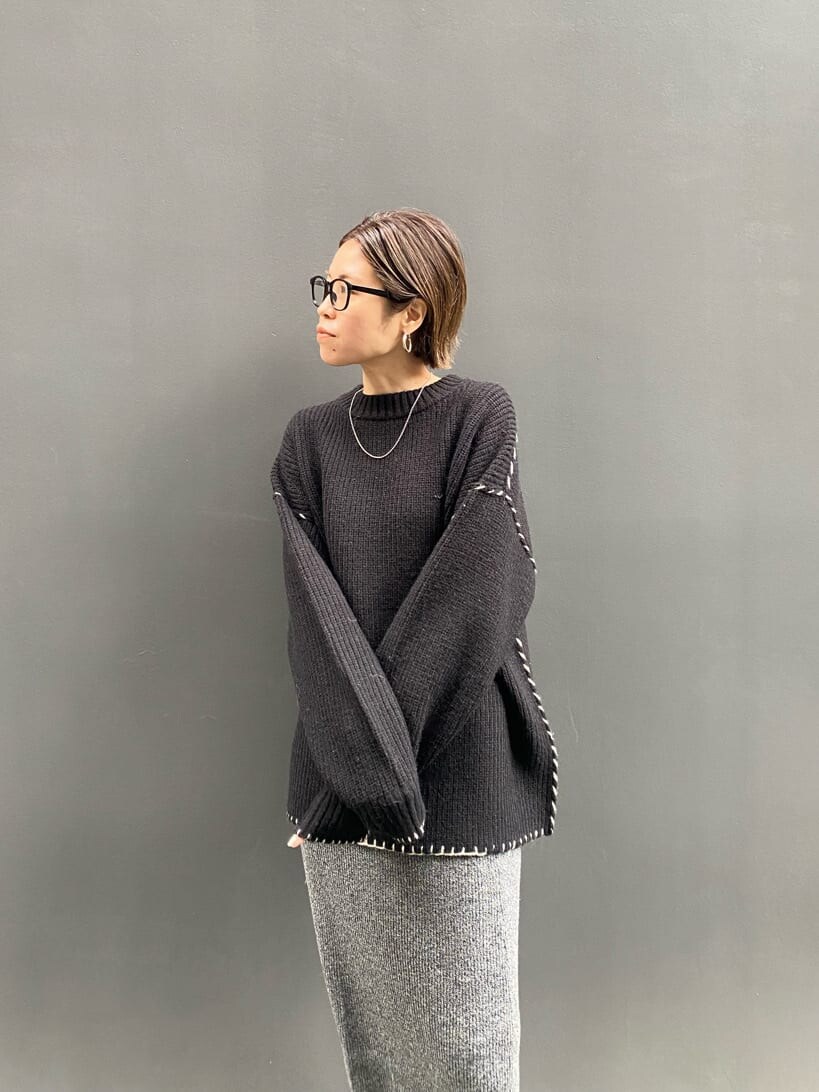 グレー系のスカート、ブラック系のニット/セーターを着用したレディースの冬コーディネートの3枚目の写真