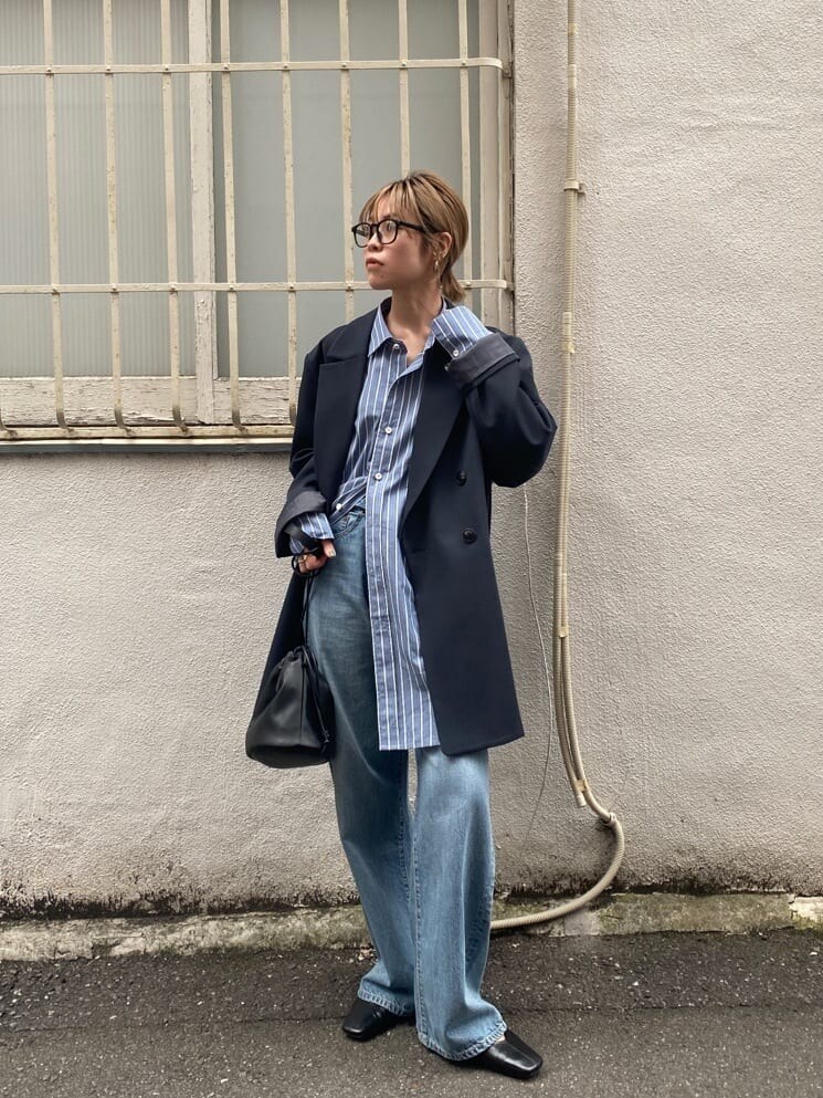 ブルー系のシャツ/ブラウス、ブラック系のパンプス、ブルー系のデニムパンツを着用したレディースの春コーディネートの3枚目の写真