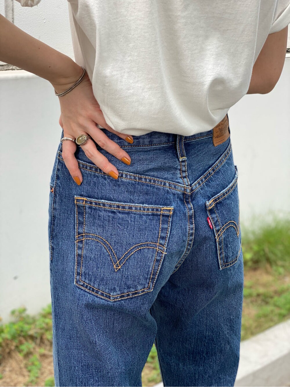 ホワイト系のTシャツ/カットソー、ブルー系のデニムパンツ、ブラック系のハットを着用したレディースの夏コーディネートの2枚目の写真