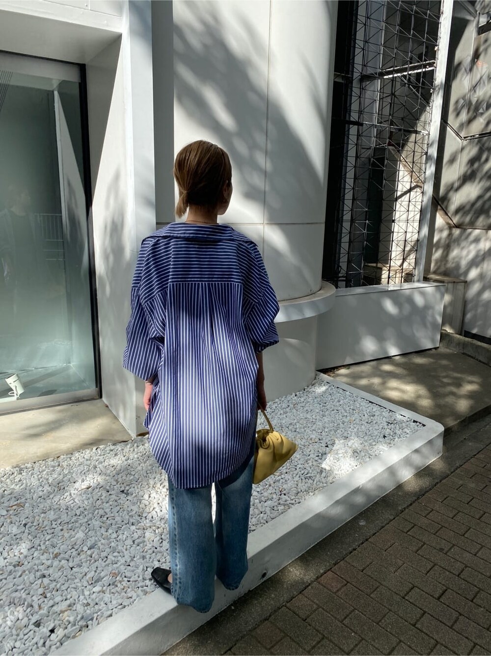 ブルー系のシャツ/ブラウス、ブルー系のデニムパンツ、ブラック系のパンプスを着用したレディースの夏コーディネートの4枚目の写真