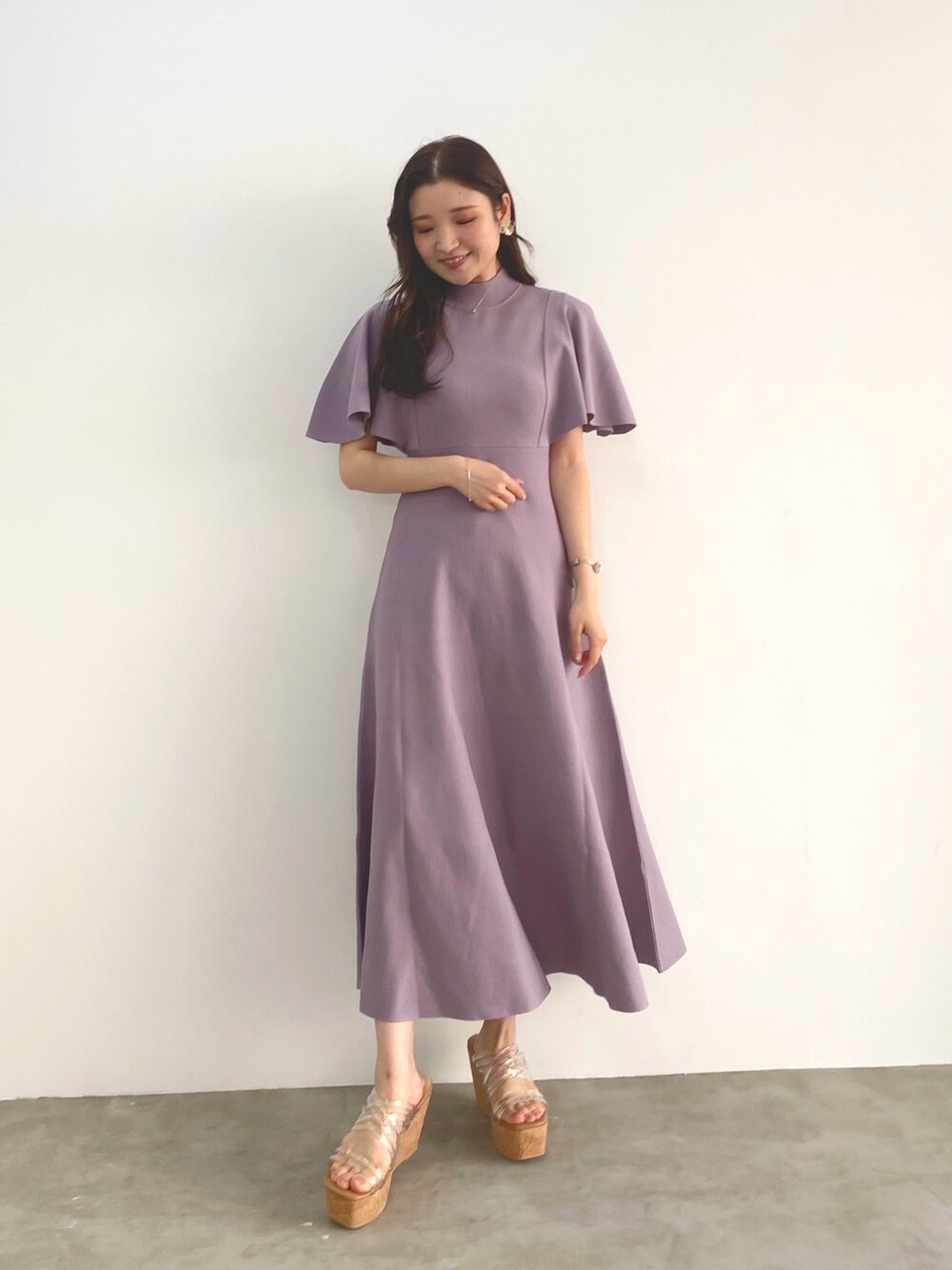 ホワイト系のサンダル、パープル系のワンピースを着用したレディースの冬コーディネートの2枚目の写真