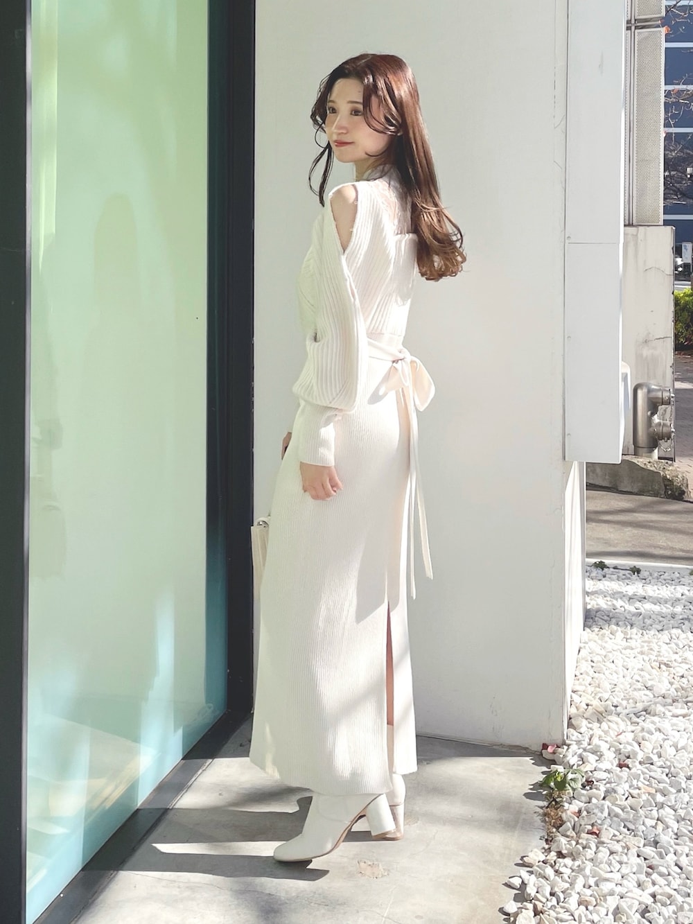 ホワイト系のブーツ、ホワイト系のショルダーバッグ、ホワイト系のワンピースを着用したレディースの冬コーディネートの3枚目の写真