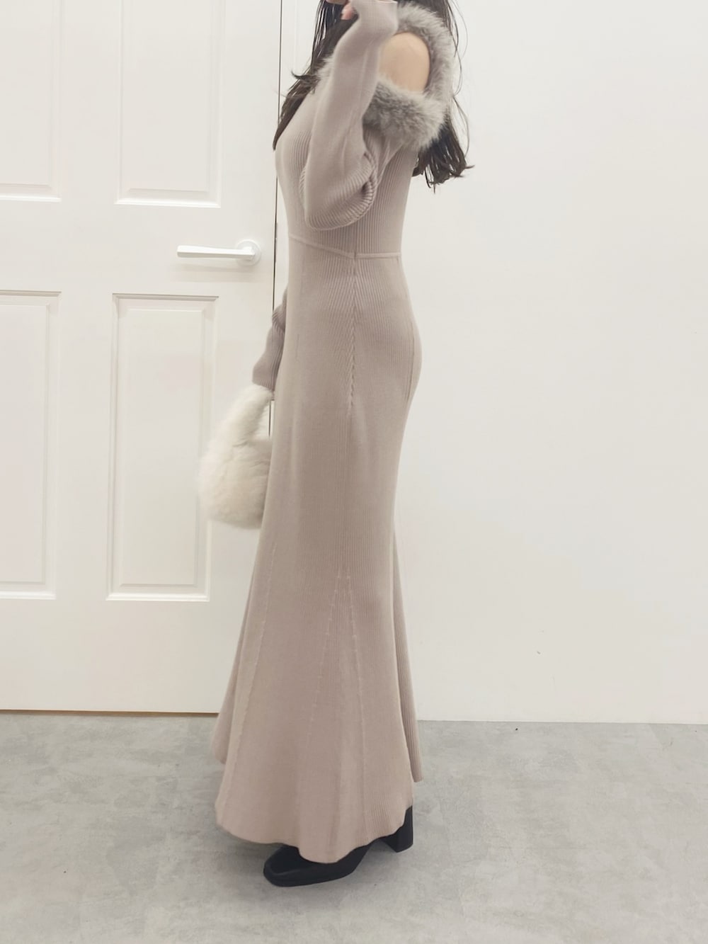 ホワイト系のハンドバッグ、ブラック系のブーツ、ベージュ系のワンピースを着用したレディースの秋コーディネートの3枚目の写真