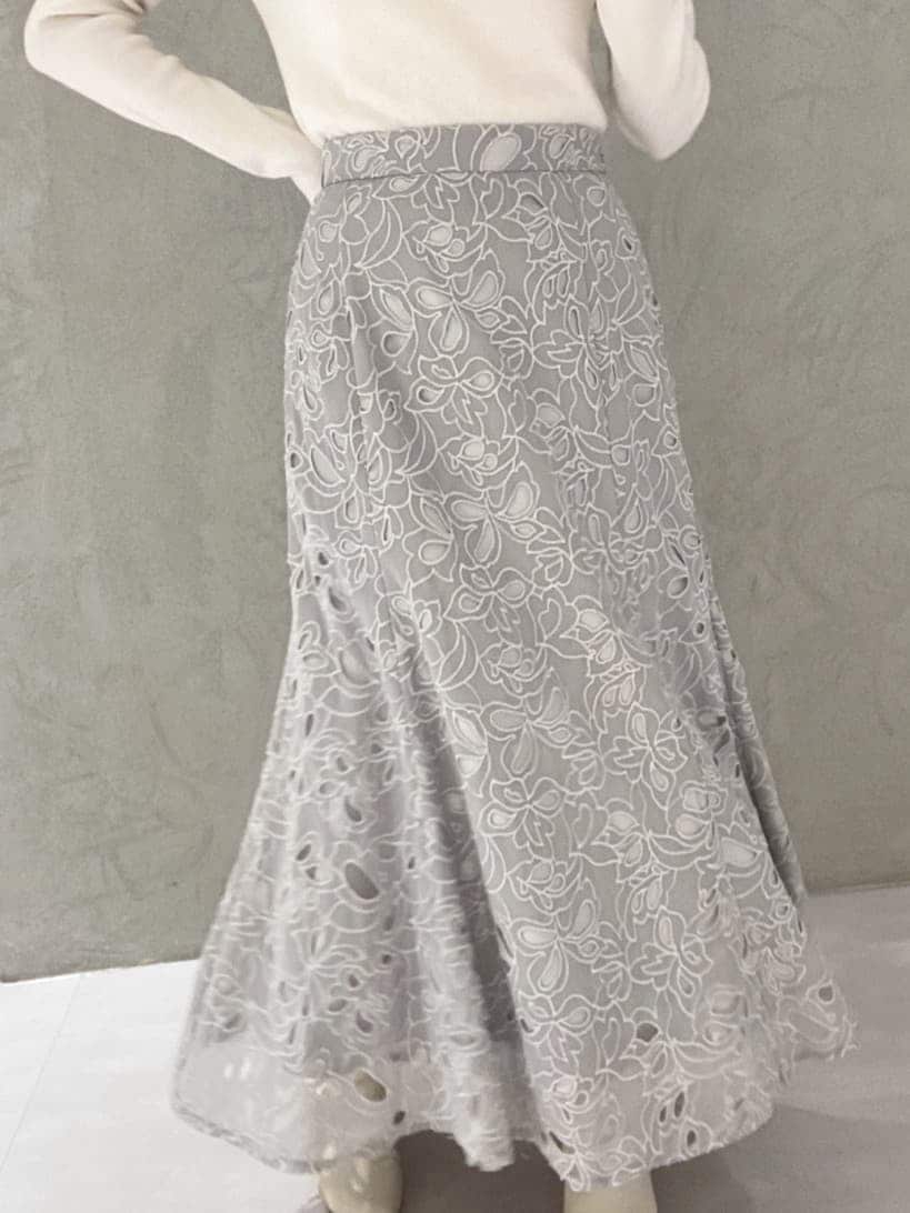 ホワイト系のニット/セーター、グレー系のスカートを着用したレディースの冬コーディネートの6枚目の写真