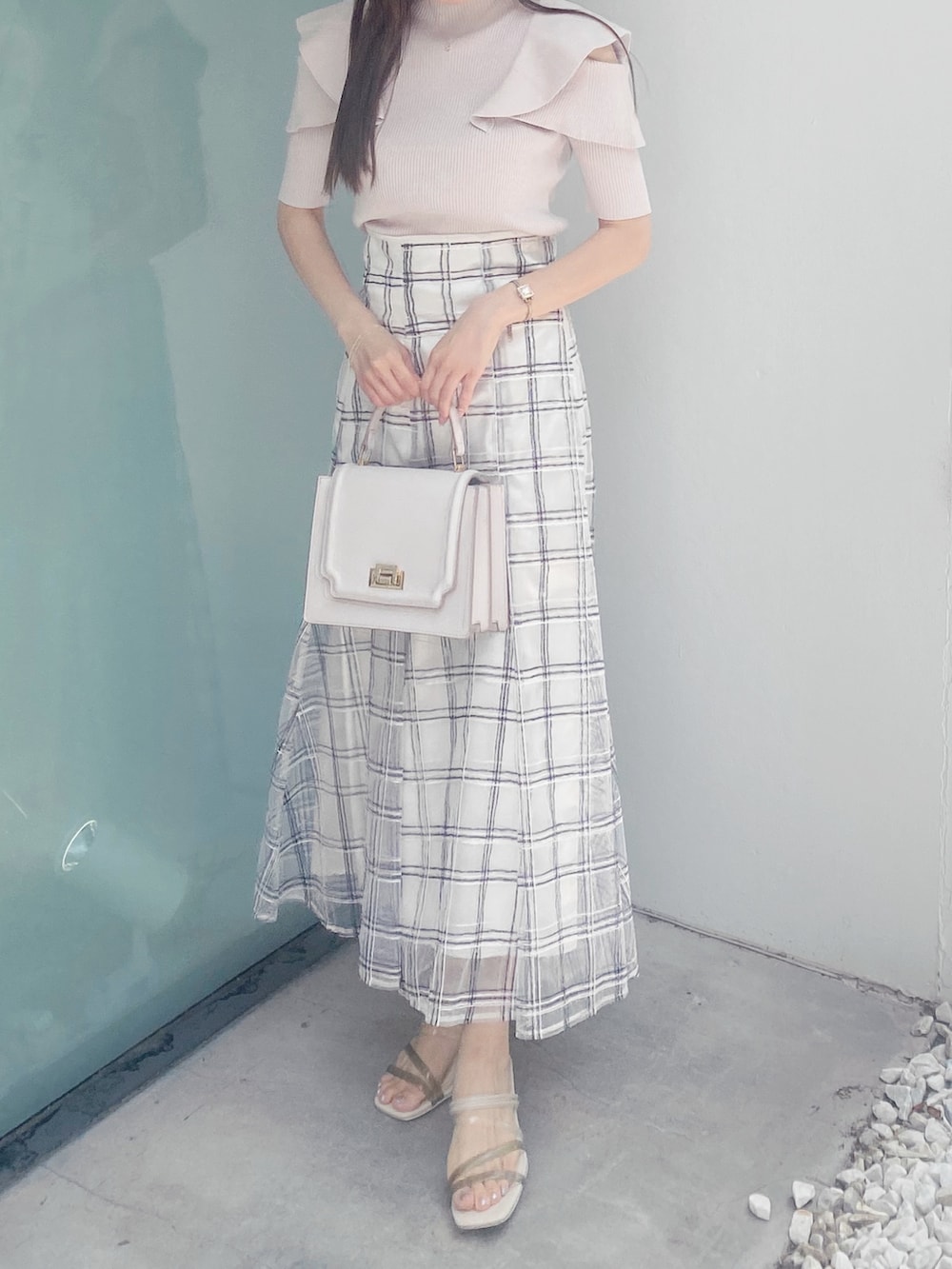 ホワイト系のサンダル、ホワイト系のハンドバッグ、ホワイト系のスカートを着用したレディースの夏コーディネートの3枚目の写真