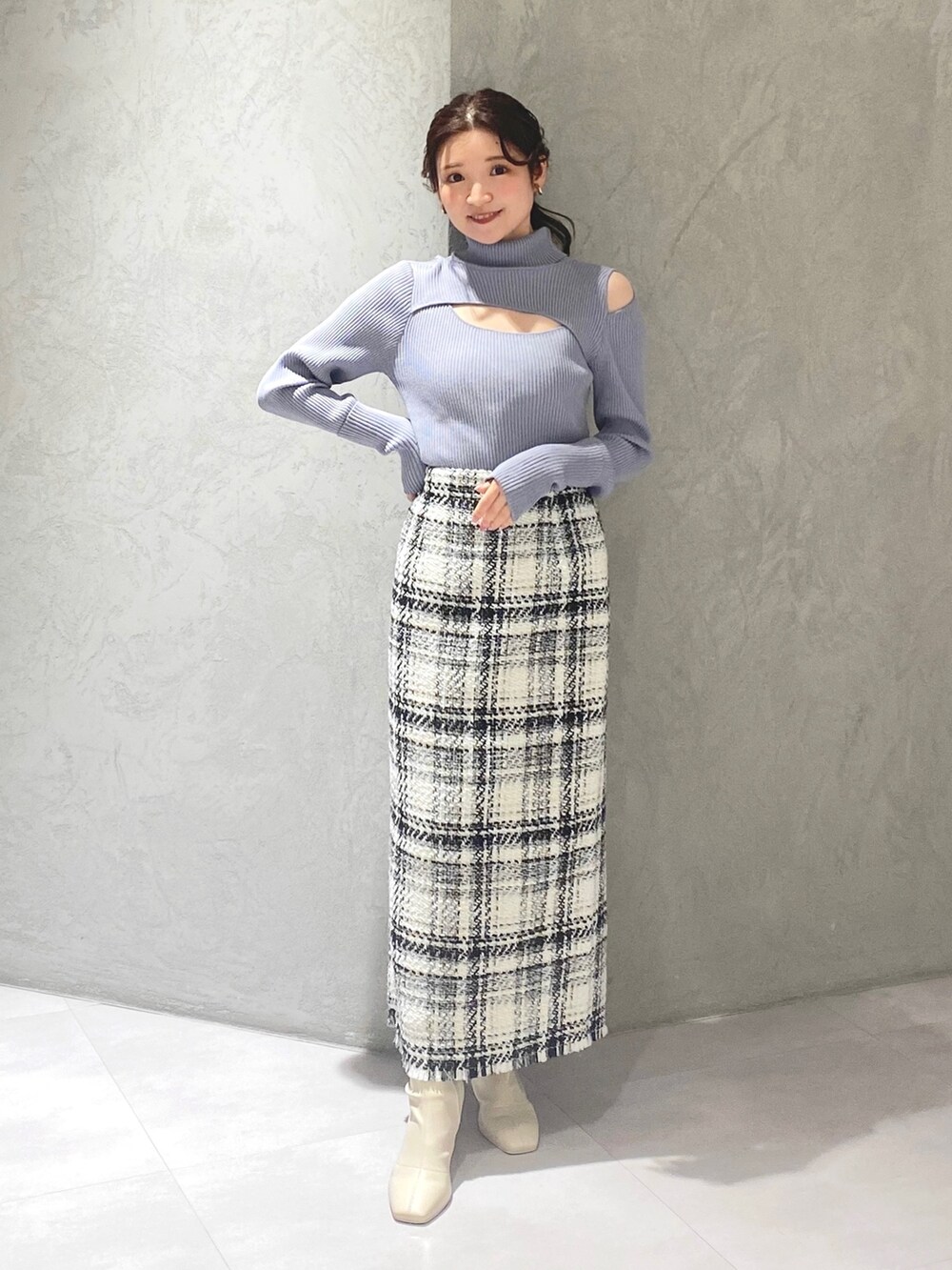 ホワイト系のブーツ、ホワイト系のスカート、ブルー系のニット/セーターを着用したレディースの冬コーディネートの3枚目の写真