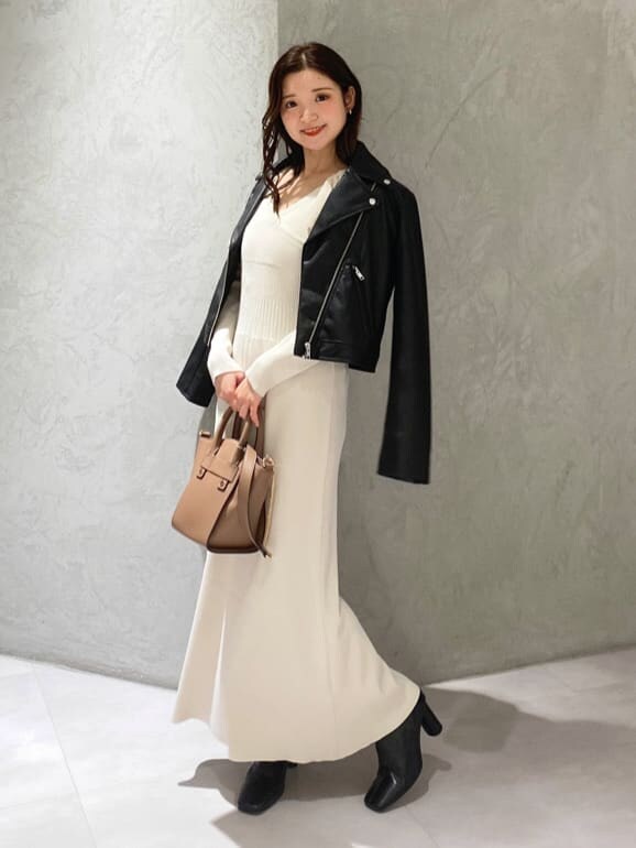 ブラック系のライダースジャケット、ブラック系のブーツ、ブラウン系のハンドバッグを着用したレディースの秋コーディネートの2枚目の写真