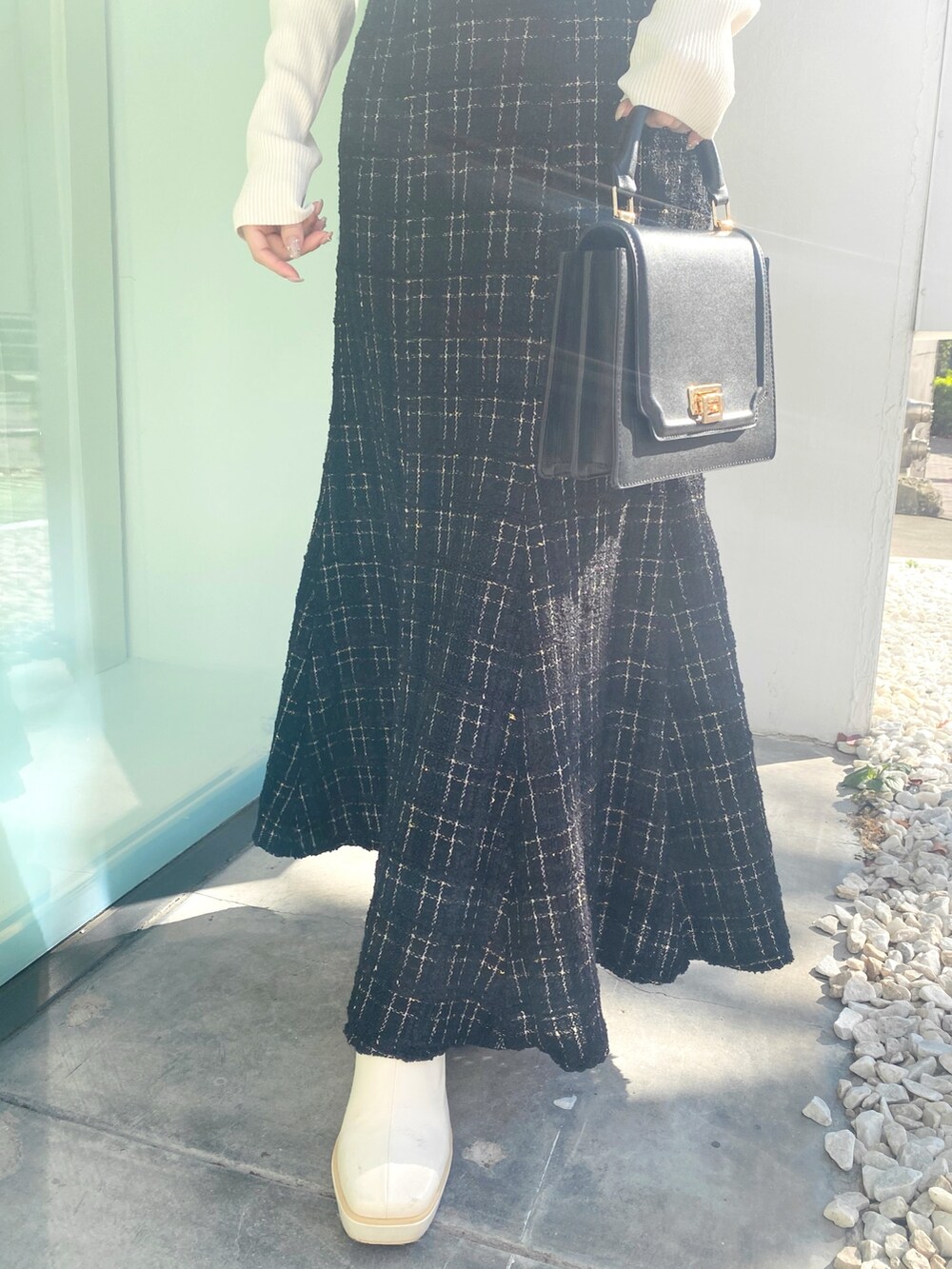 ホワイト系のブーツ、ブラック系のハンドバッグ、ブラック系のワンピースを着用したレディースの冬コーディネートの6枚目の写真