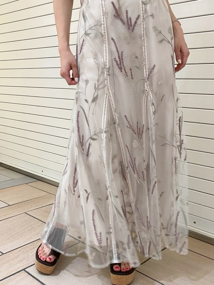 ホワイト系のスカート、ブラウン系のサンダル、ブラウン系のニット/セーターを着用したレディースの夏コーディネートの2枚目の写真