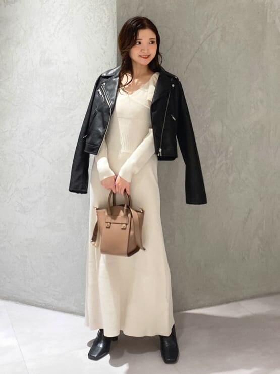 ブラック系のライダースジャケット、ブラック系のブーツ、ブラウン系のハンドバッグを着用したレディースの秋コーディネートの3枚目の写真