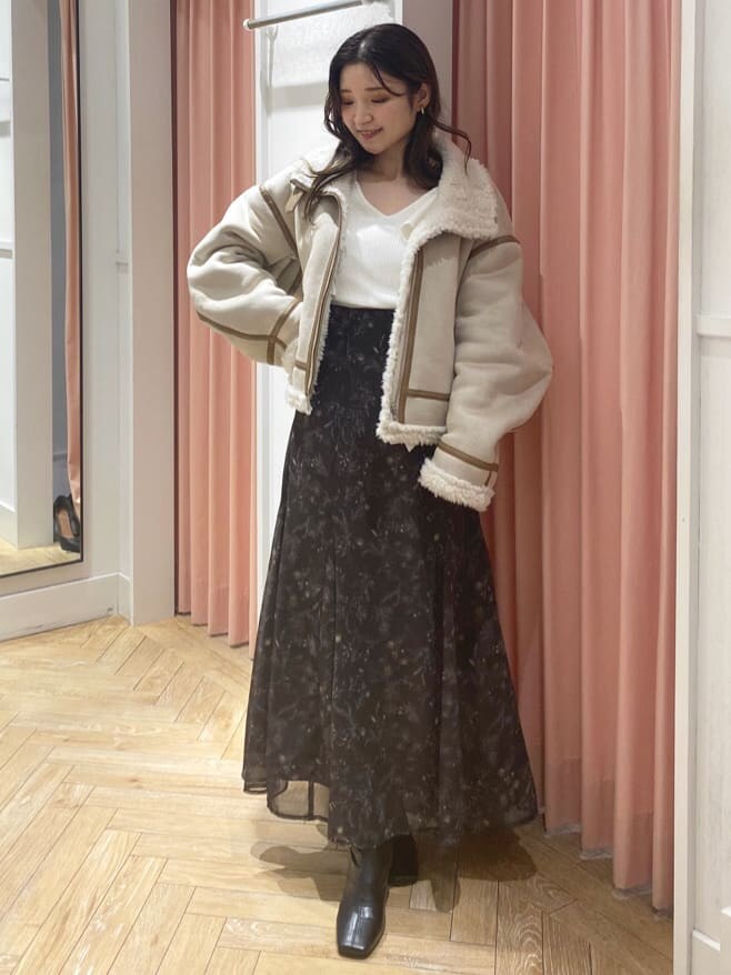 ベージュ系のムートンコート、ブラック系のブーツ、ホワイト系のニット/セーターを着用したレディースの秋コーディネートの4枚目の写真