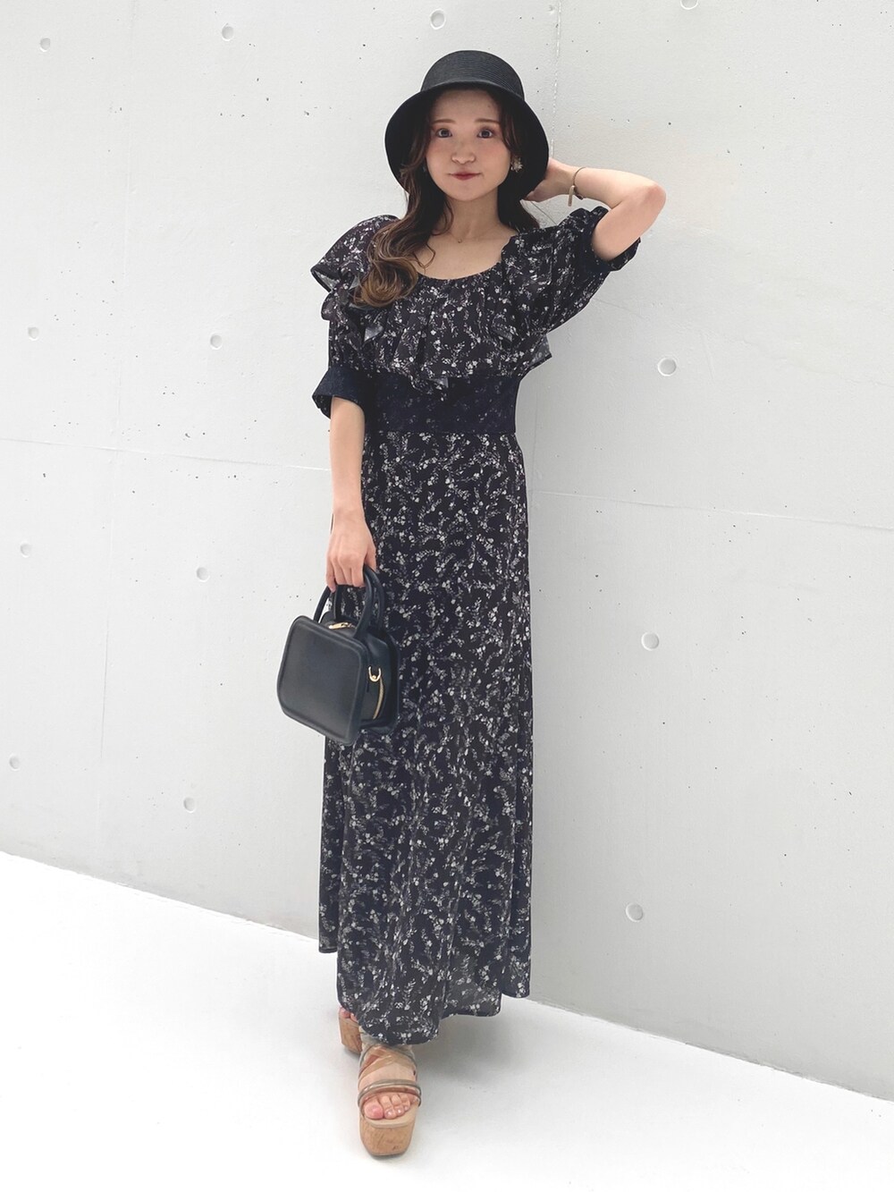ブラック系のワンピース、その他のサンダル、ブラック系のハンドバッグを着用したレディースの夏コーディネートの2枚目の写真