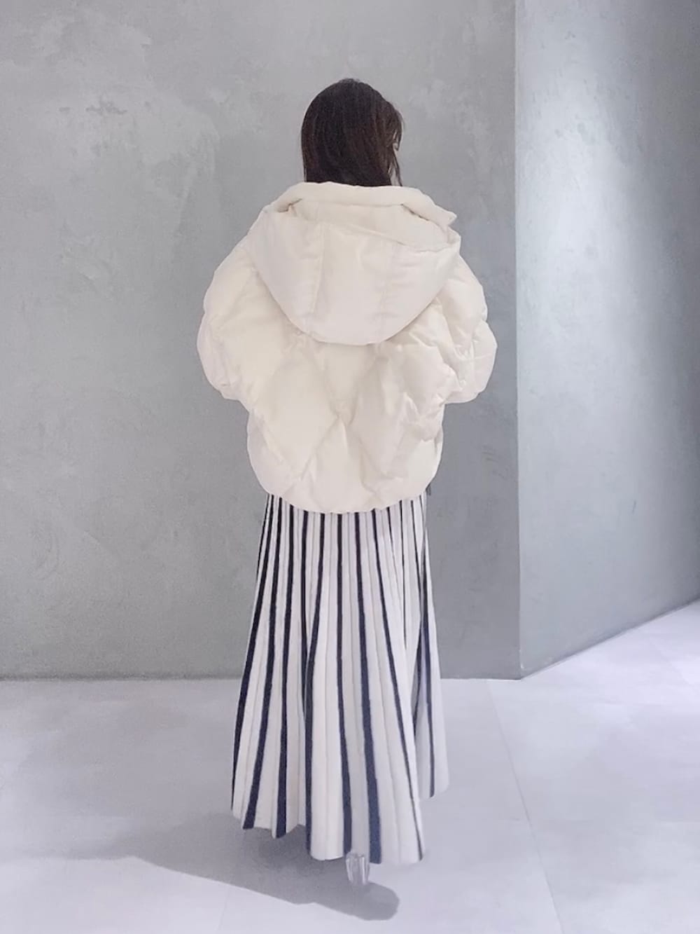 ホワイト系のワンピース、ホワイト系のブーツ、ブラウン系のハンドバッグを着用したレディースの冬コーディネートの5枚目の写真