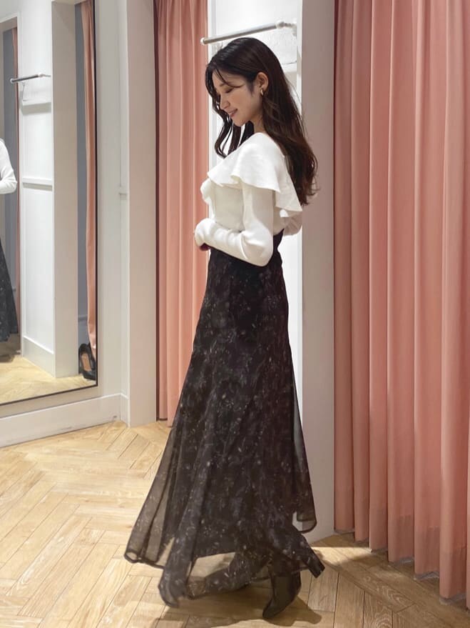 ブラック系のブーツ、ホワイト系のニット/セーター、ブラウン系のスカートを着用したレディースの秋コーディネートの3枚目の写真