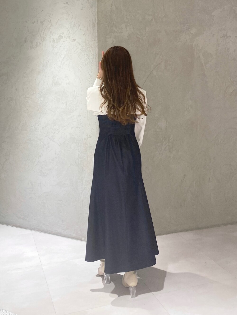 ホワイト系のブーツ、ブルー系のワンピース、ホワイト系のハンドバッグを着用したレディースの冬コーディネートの7枚目の写真