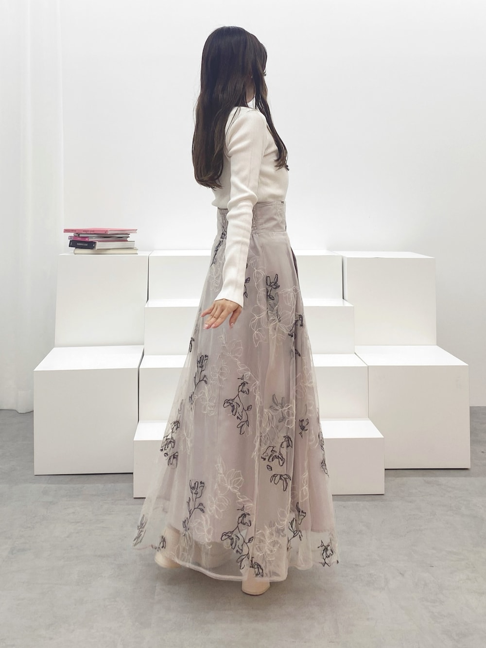 ホワイト系のブーツ、ホワイト系のニット/セーター、ベージュ系のスカートを着用したレディースの秋コーディネートの7枚目の写真