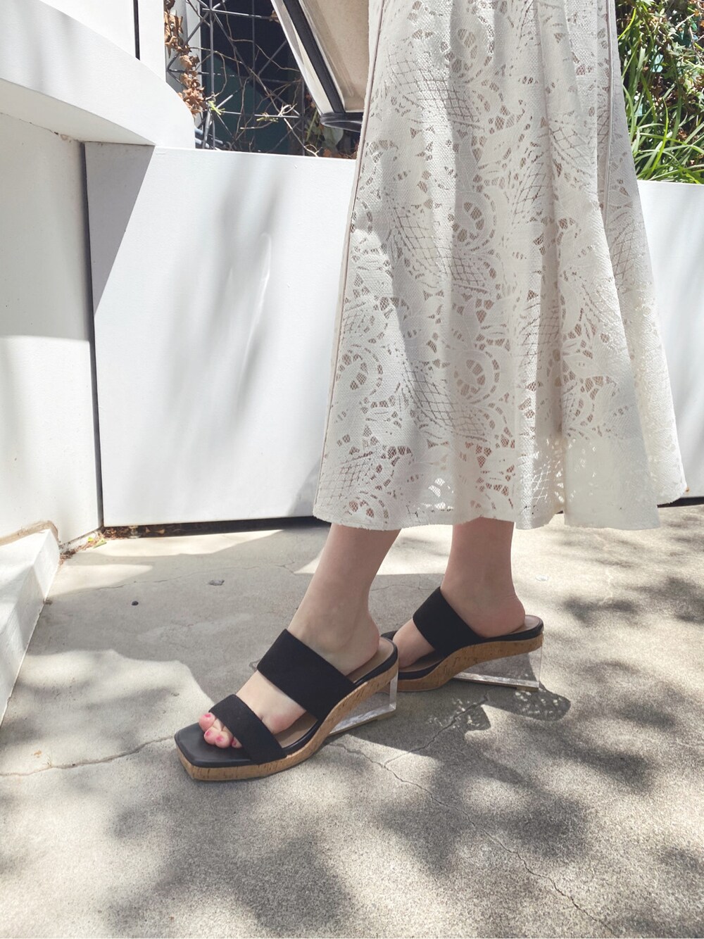 ホワイト系のスカート、ブラック系のサンダル、ホワイト系のニット/セーターを着用したレディースの春コーディネートの5枚目の写真