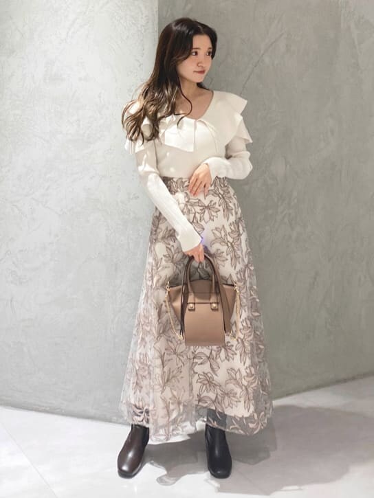 ブラウン系のハンドバッグ、ホワイト系のニット/セーター、ピンク系のスカートを着用したレディースの秋コーディネートの3枚目の写真