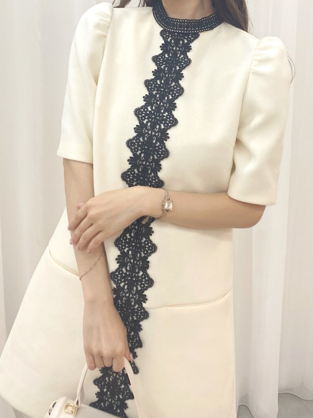 ホワイト系のハンドバッグ、ホワイト系のワンピース、ブラック系のブーツを着用したレディースの夏コーディネートの6枚目の写真