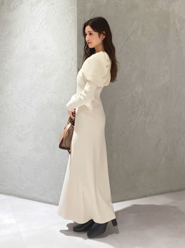 ブラック系のブーツ、ブラウン系のハンドバッグ、ホワイト系のワンピースを着用したレディースの秋コーディネートの3枚目の写真