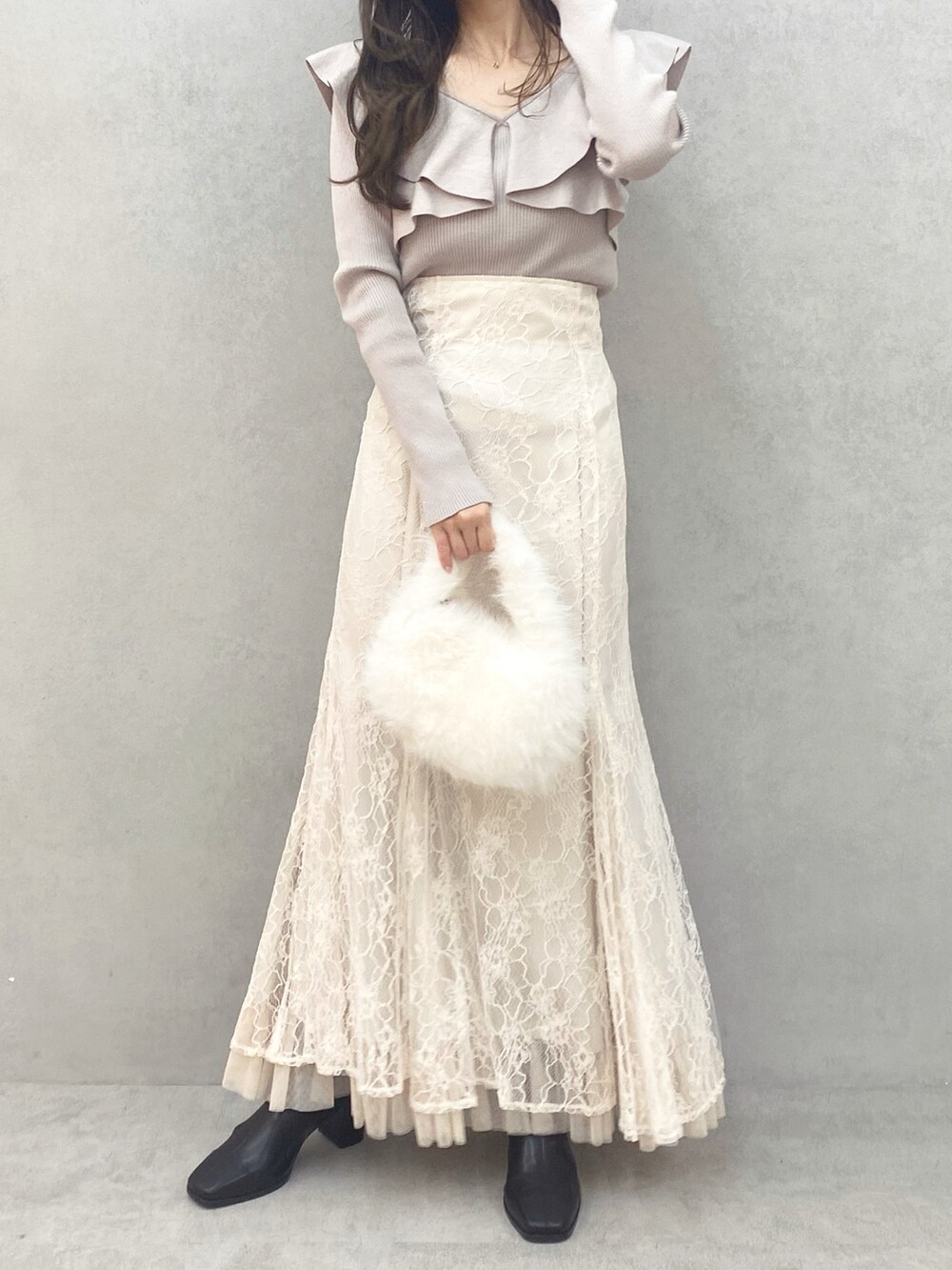 ブラック系のブーツ、ピンク系のニット/セーター、ホワイト系のスカートを着用したレディースの秋コーディネートの2枚目の写真