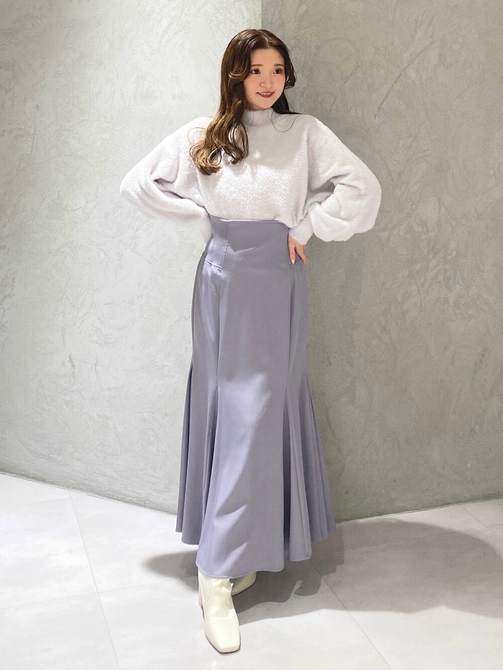 ホワイト系のブーツ、ブルー系のスカート、パープル系のニット/セーターを着用したレディースの秋コーディネートの2枚目の写真