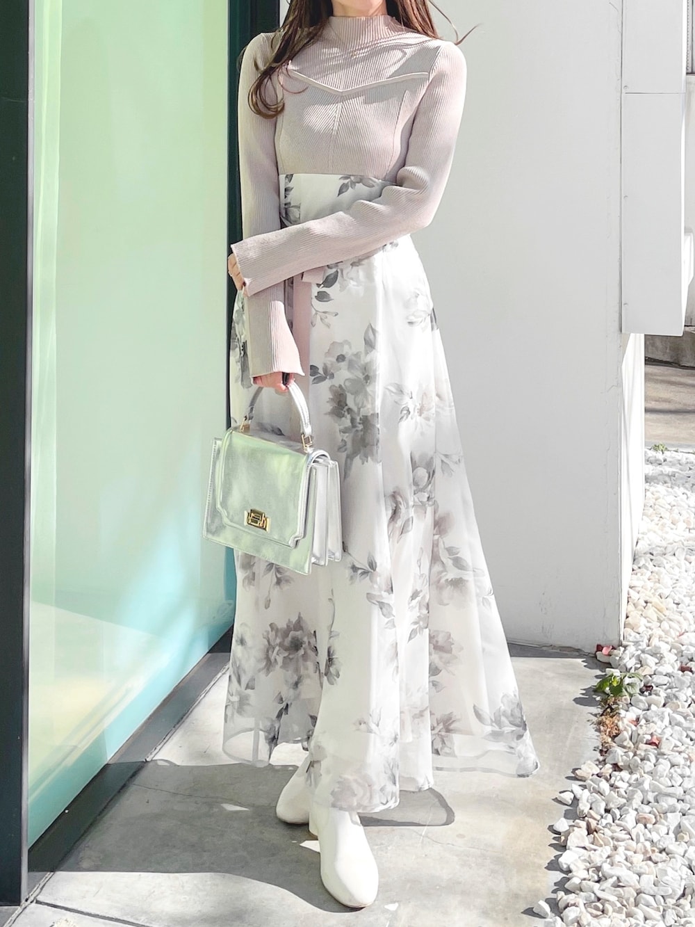 ベージュ系のワンピース、ホワイト系のブーツ、シルバー系のハンドバッグを着用したレディースの冬コーディネートの2枚目の写真