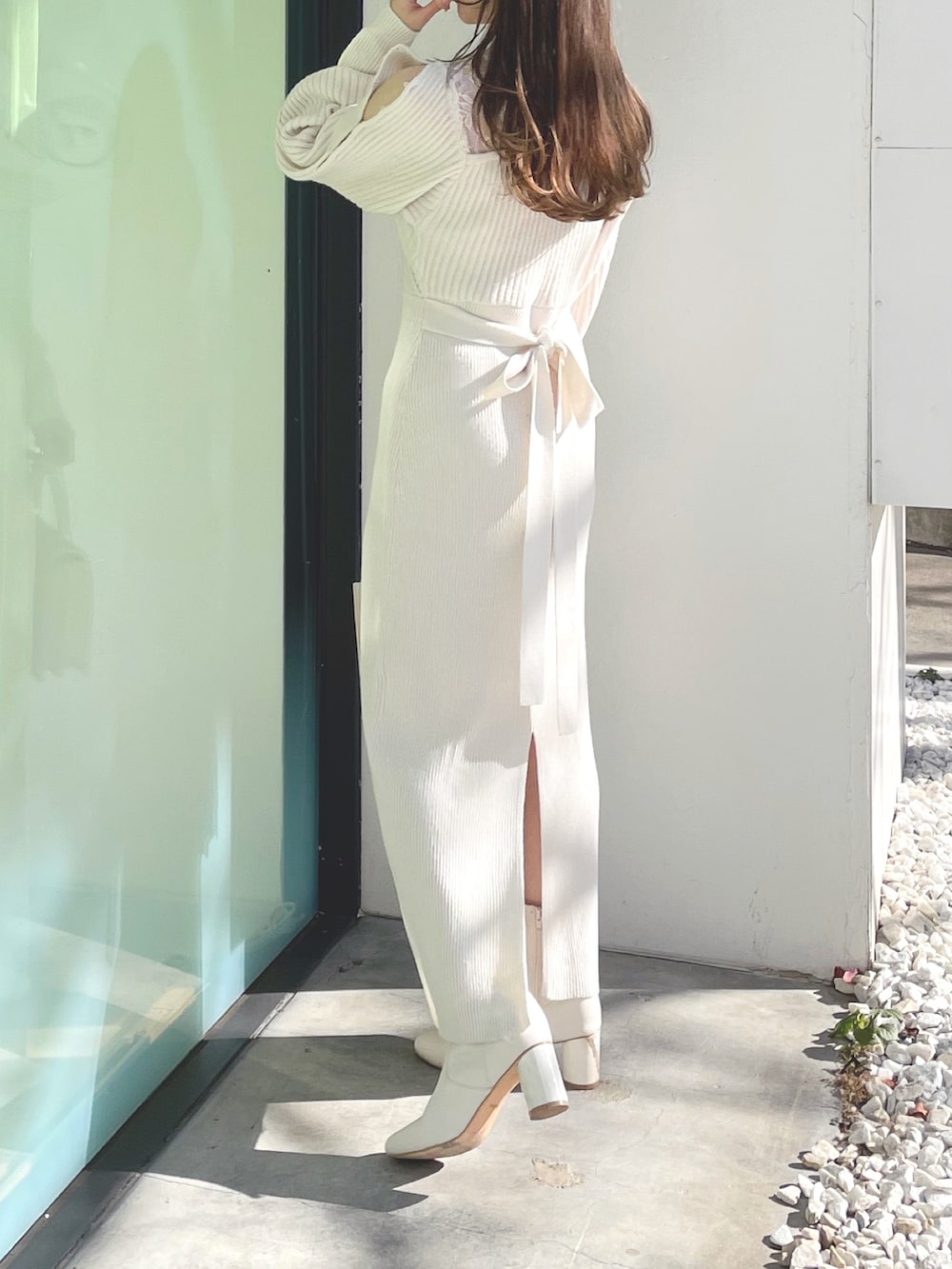 ホワイト系のブーツ、ホワイト系のショルダーバッグ、ホワイト系のワンピースを着用したレディースの冬コーディネートの6枚目の写真