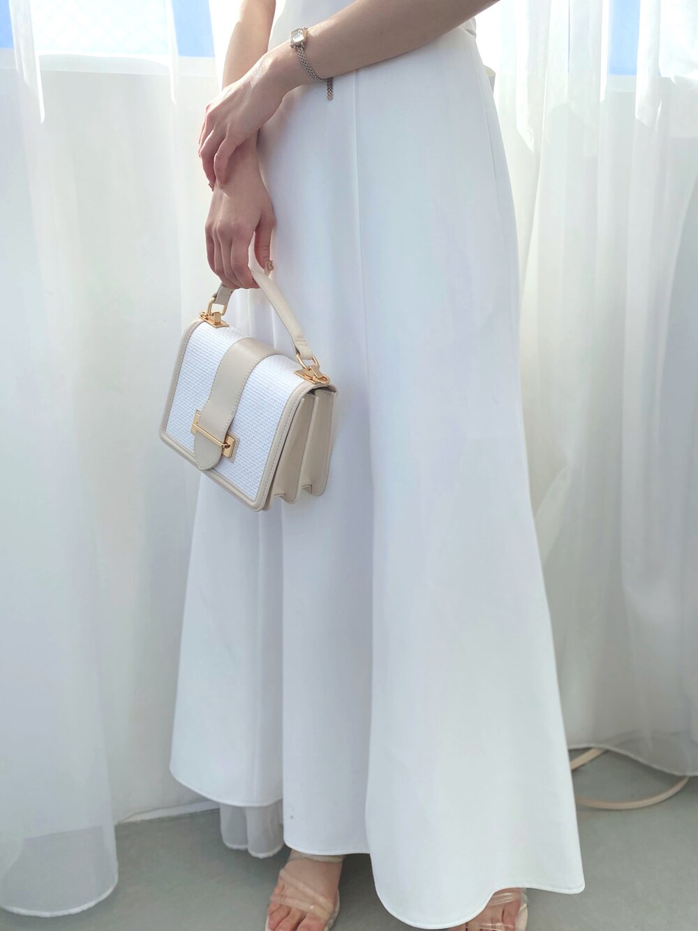 その他のサンダル、ホワイト系のハンドバッグ、パープル系のワンピースを着用したレディースの夏コーディネートの5枚目の写真