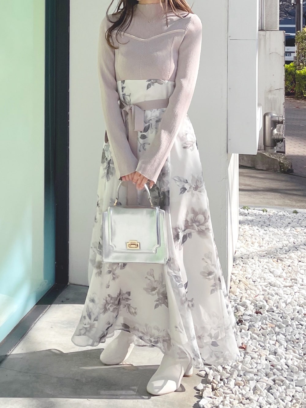 ベージュ系のワンピース、ホワイト系のブーツ、シルバー系のハンドバッグを着用したレディースの冬コーディネートの4枚目の写真