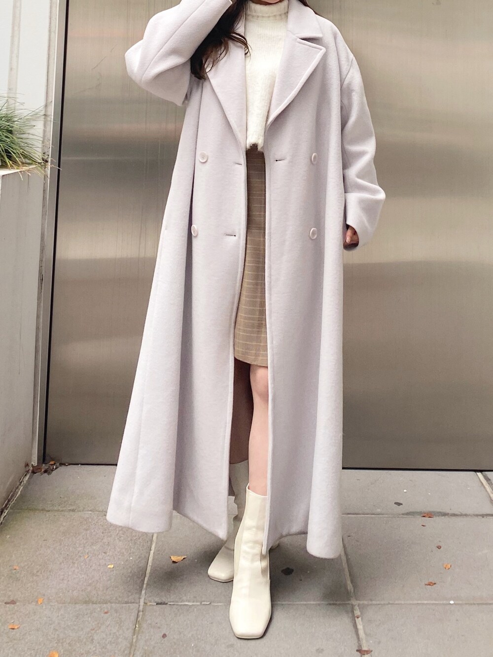 ホワイト系のニット/セーター、ベージュ系のスカート、ホワイト系のブーツを着用したレディースの秋コーディネートの2枚目の写真