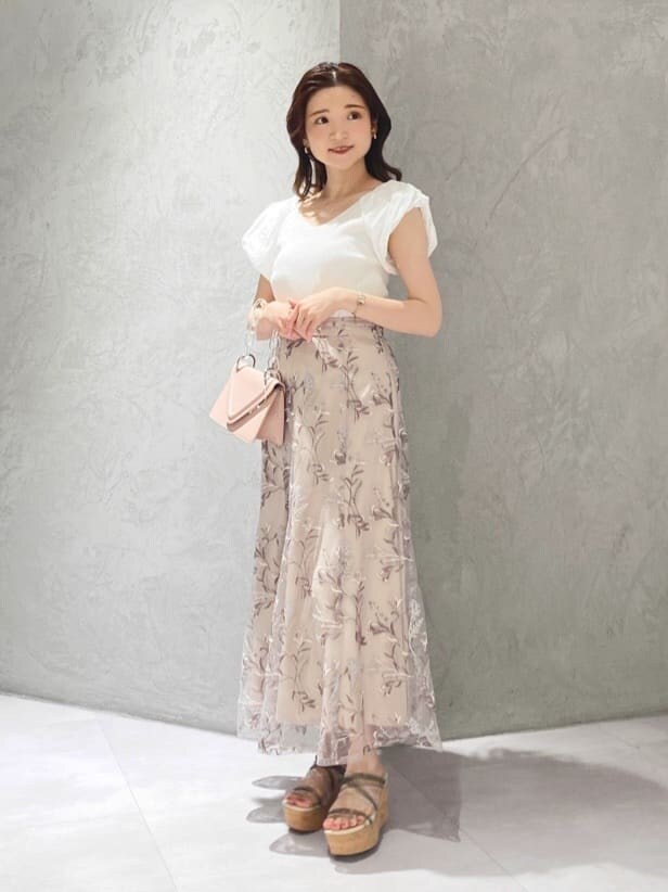 ピンク系のスカート、ホワイト系のニット/セーターを着用したレディースの春コーディネートの2枚目の写真