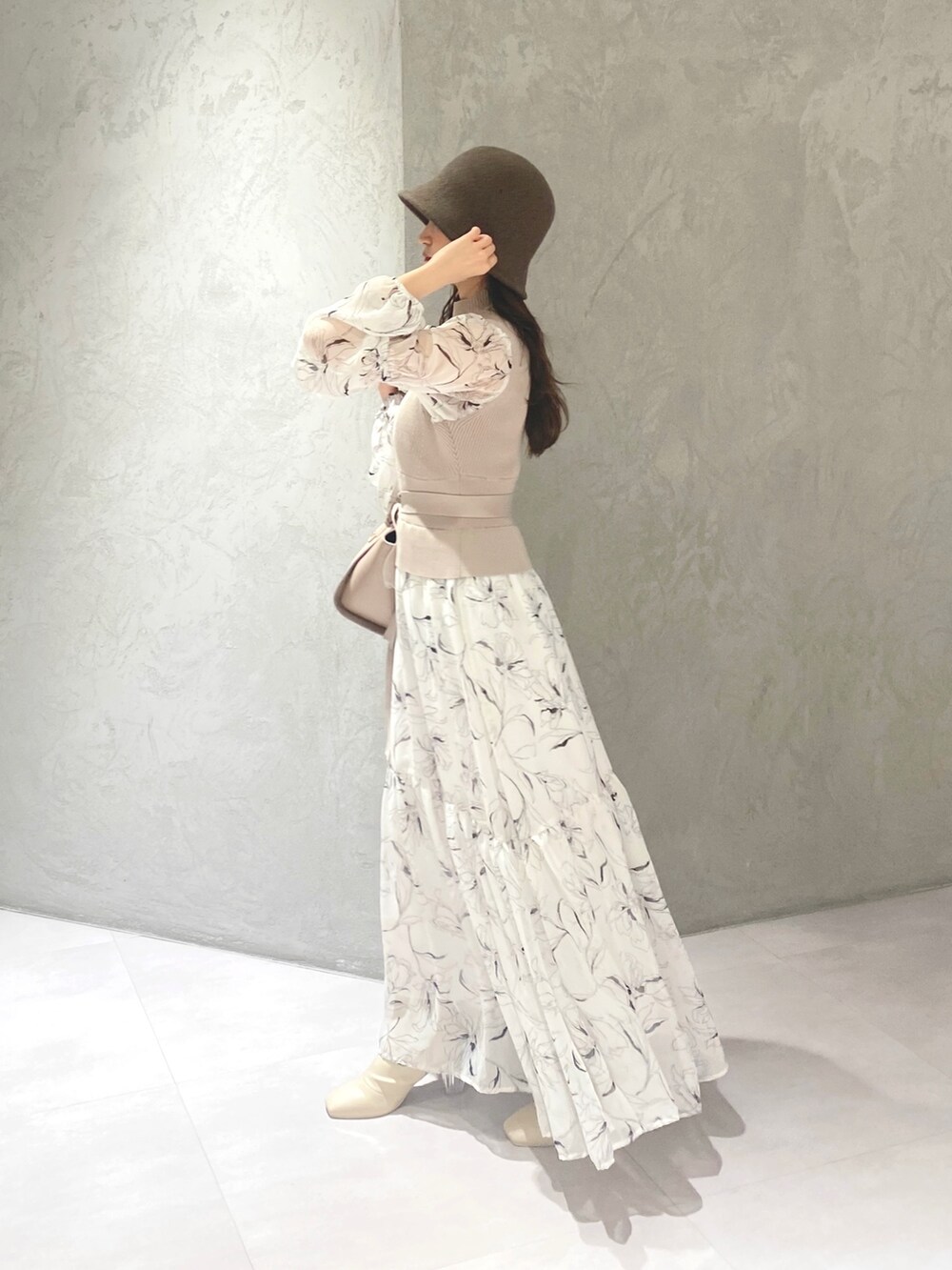 ホワイト系のワンピース、ベージュ系のハンドバッグ、ホワイト系のブーツを着用したレディースの冬コーディネートの4枚目の写真