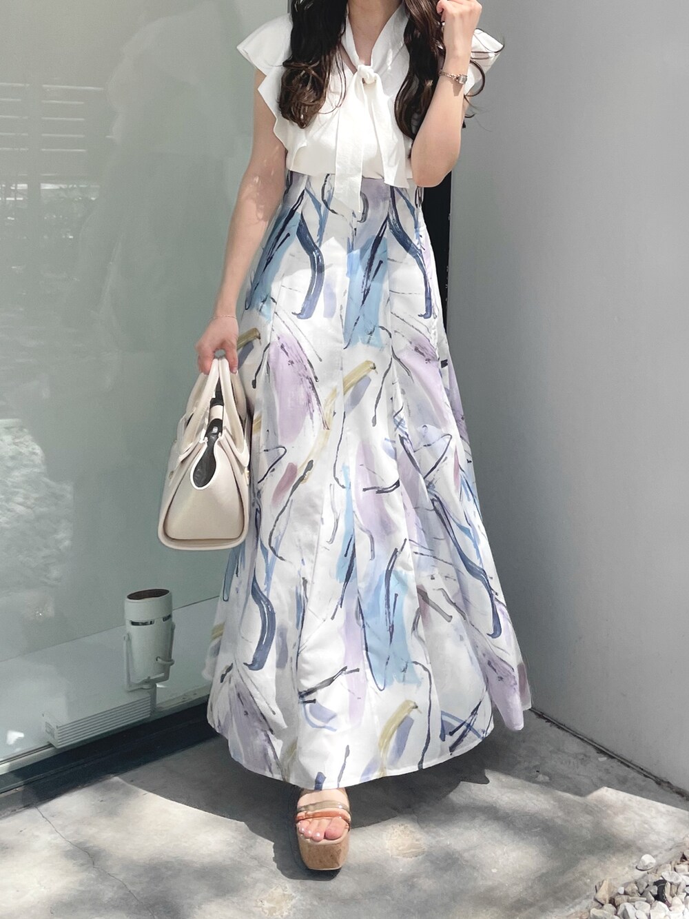 その他のサンダル、ホワイト系のニット/セーター、ホワイト系のハンドバッグを着用したレディースの夏コーディネートの3枚目の写真