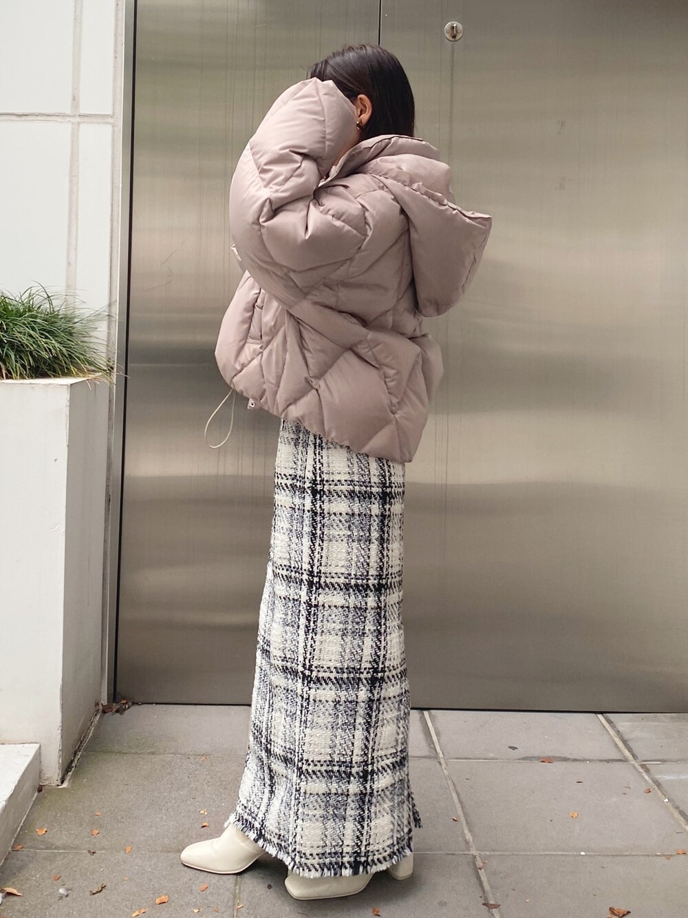 ホワイト系のブーツ、ホワイト系のスカート、ベージュ系のダウンジャケット/コートを着用したレディースの秋コーディネートの3枚目の写真