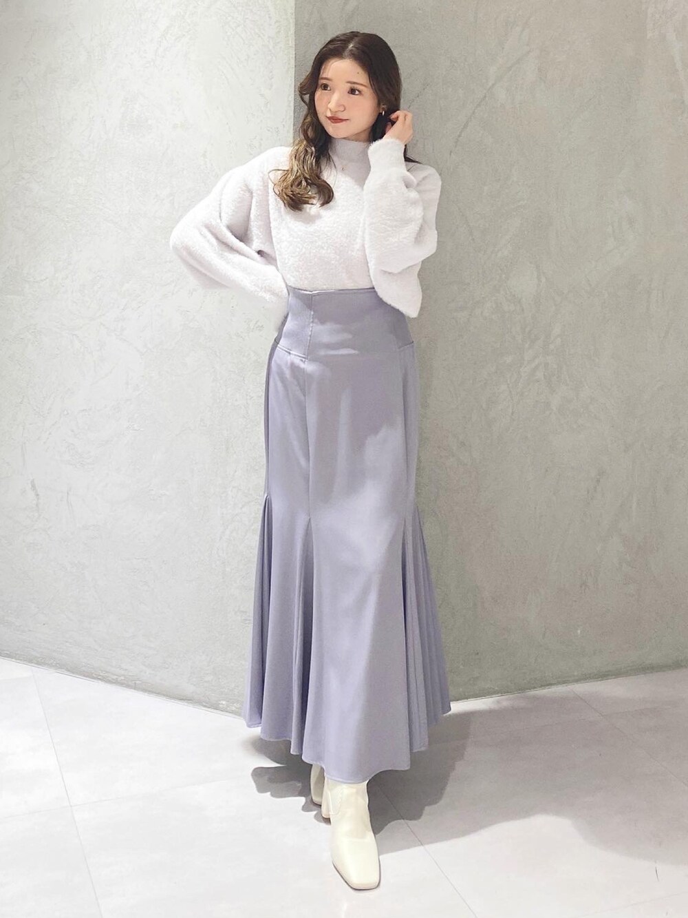 ホワイト系のチェスターコート、ホワイト系のブーツ、パープル系のニット/セーターを着用したレディースの冬コーディネートの8枚目の写真