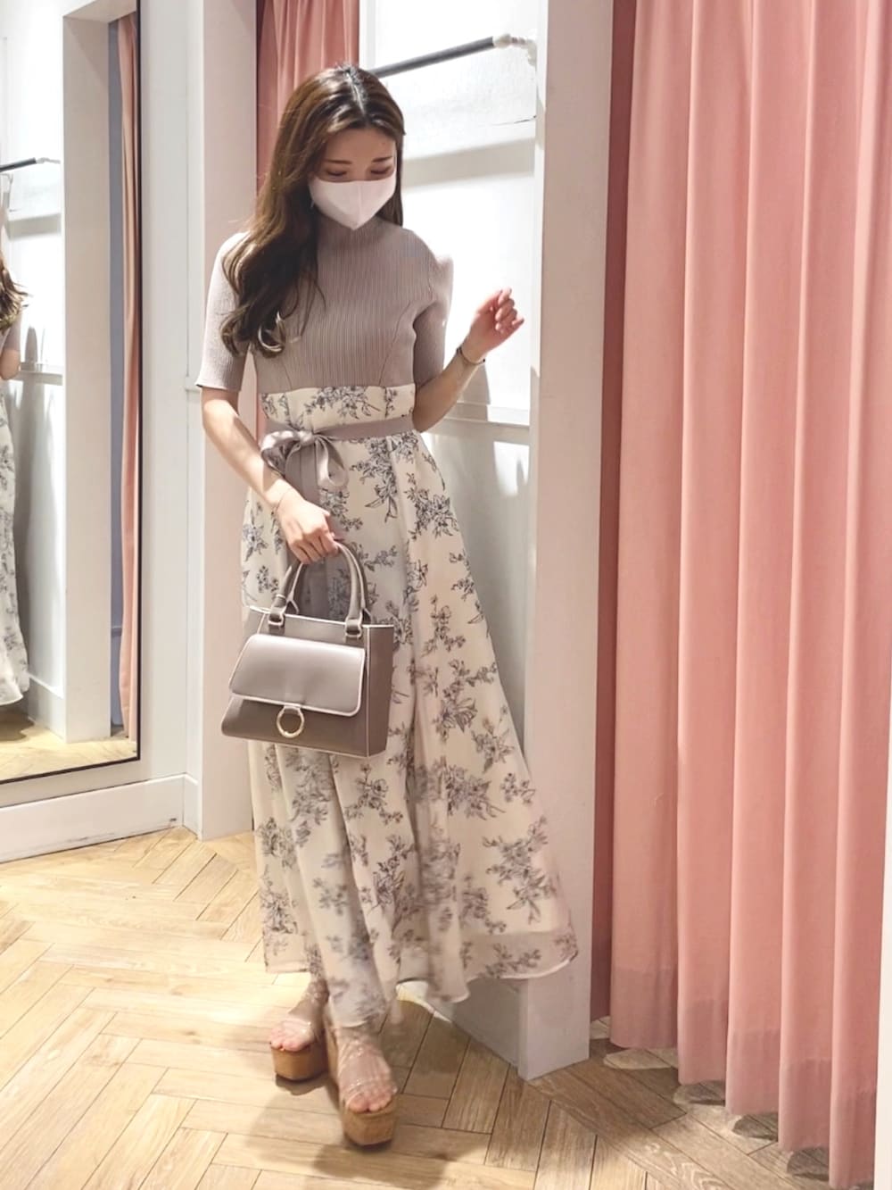 ホワイト系のサンダル、ベージュ系のハンドバッグ、ホワイト系のワンピースを着用したレディースの冬コーディネートの3枚目の写真