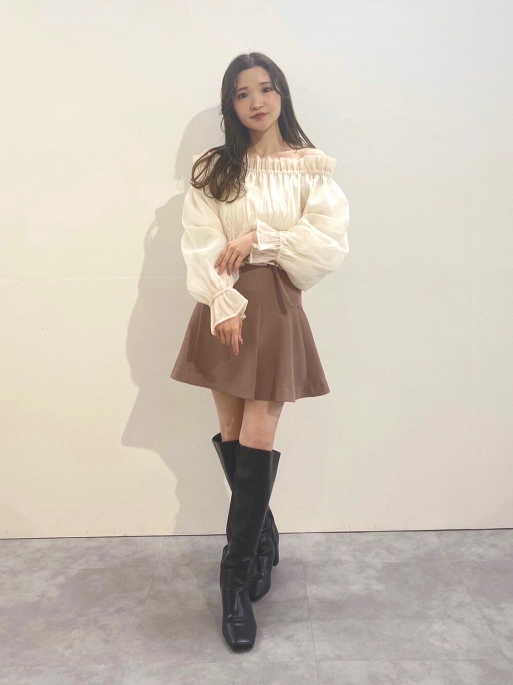 ブラウン系のその他パンツ、ホワイト系のシャツ/ブラウス、ブラック系のブーツを着用したレディースの冬コーディネートの2枚目の写真