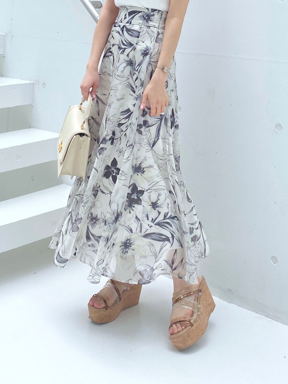 ホワイト系のニット/セーター、ブラウン系のサンダル、ホワイト系のハンドバッグを着用したレディースの夏コーディネートの2枚目の写真