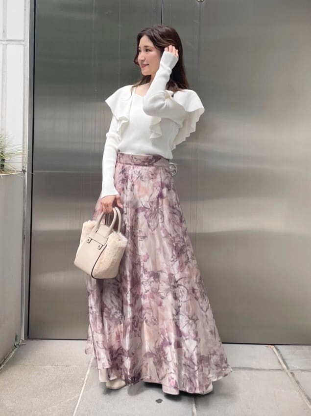 ホワイト系のハンドバッグ、ピンク系のスカート、ホワイト系のニット/セーターを着用したレディースの秋コーディネートの2枚目の写真