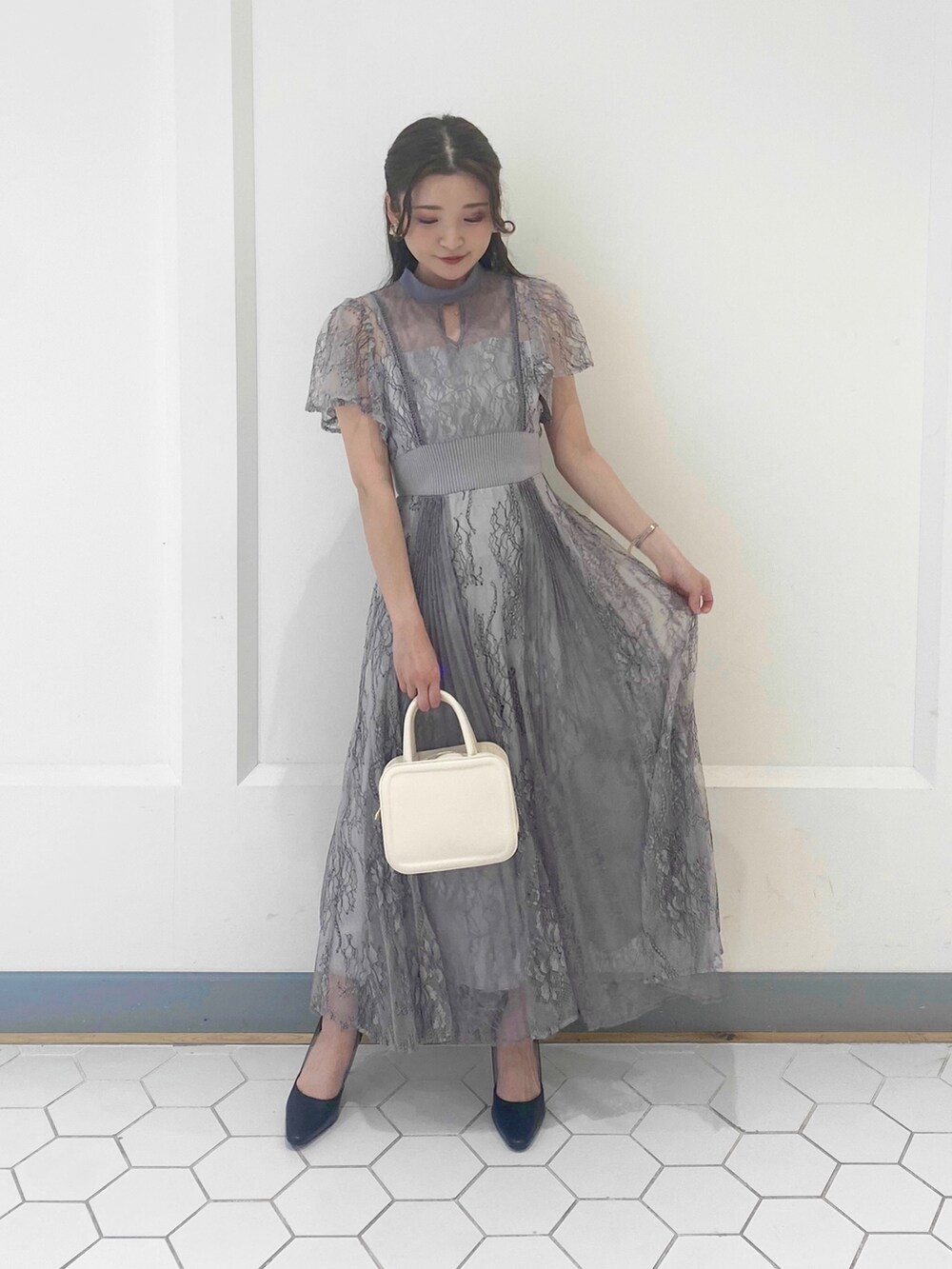 パープル系のドレス、ブラック系のパンプスを着用したレディースの冬コーディネートの4枚目の写真