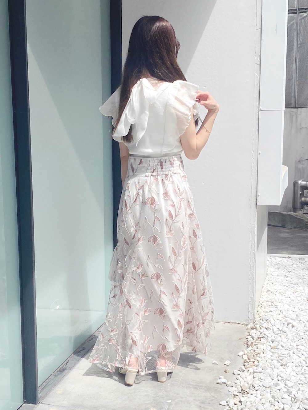 ホワイト系のサンダル、ホワイト系のショルダーバッグ、ピンク系のスカートを着用したレディースの夏コーディネートの6枚目の写真