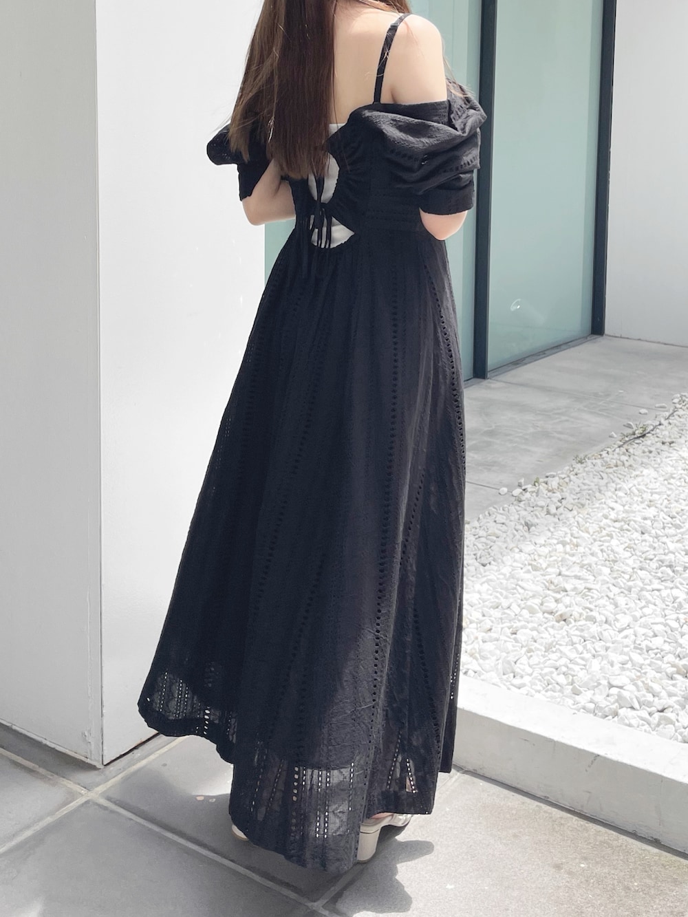 ブラック系のワンピース、ホワイト系のサンダルを着用したレディースの夏コーディネートの6枚目の写真