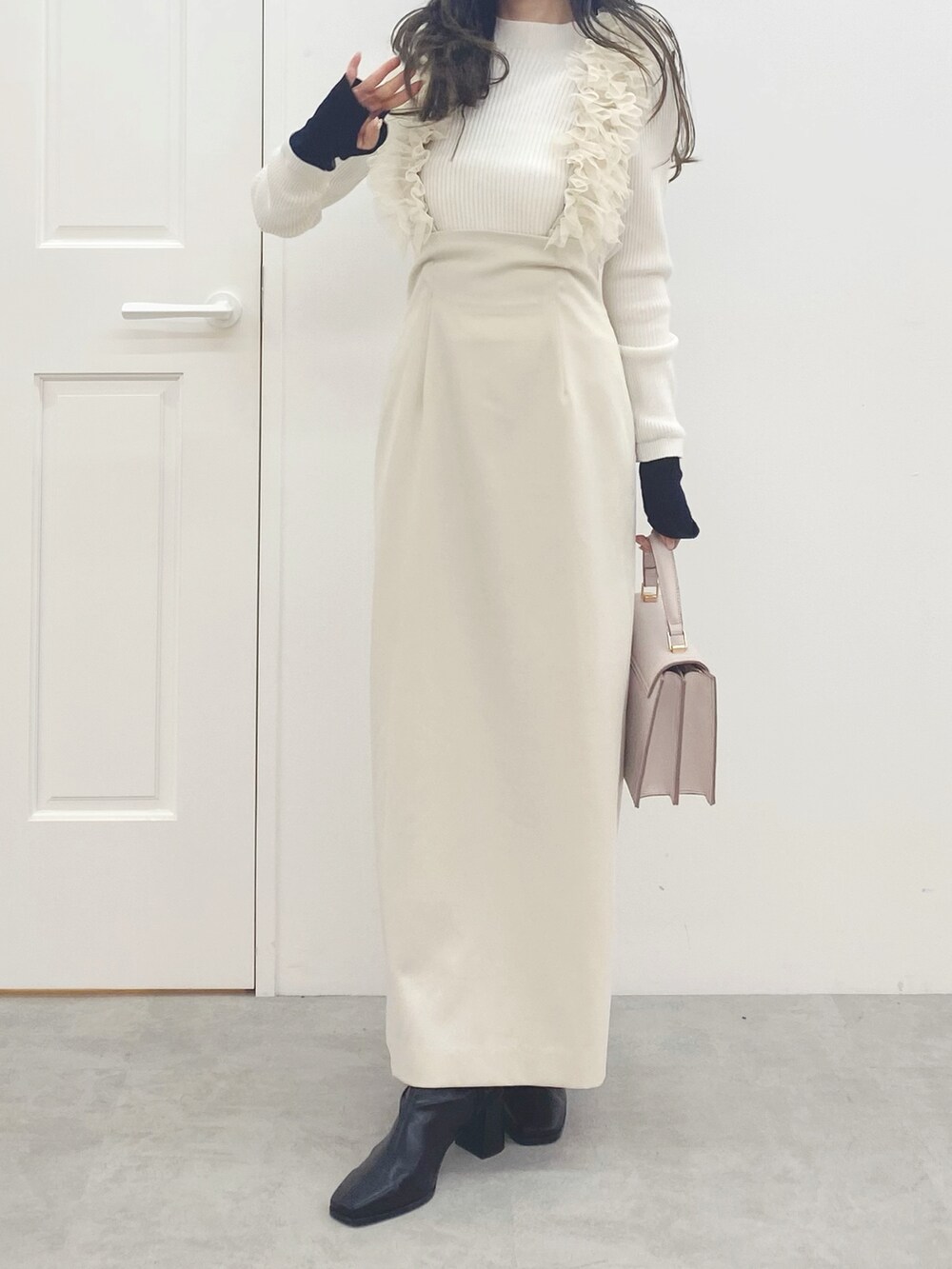 ピンク系のハンドバッグ、ブラック系のブーツ、ホワイト系のスカートを着用したレディースの秋コーディネートの3枚目の写真