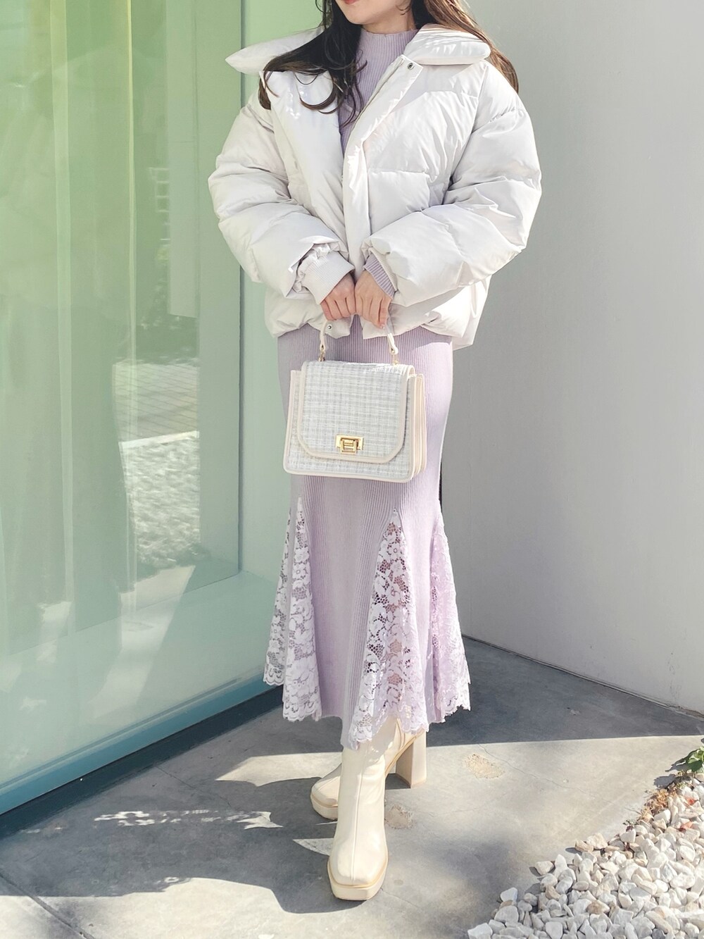 ピンク系のワンピース、ホワイト系のショルダーバッグ、ホワイト系のブーツを着用したレディースの冬コーディネートの2枚目の写真